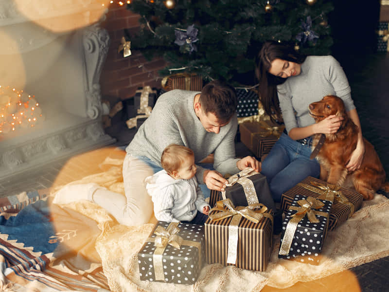 Picture of family sitting next to christmas tree and presents